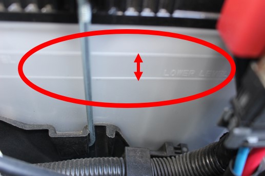 エンジンルーム内のバッテリータンクの画像。適量ラインを示している。